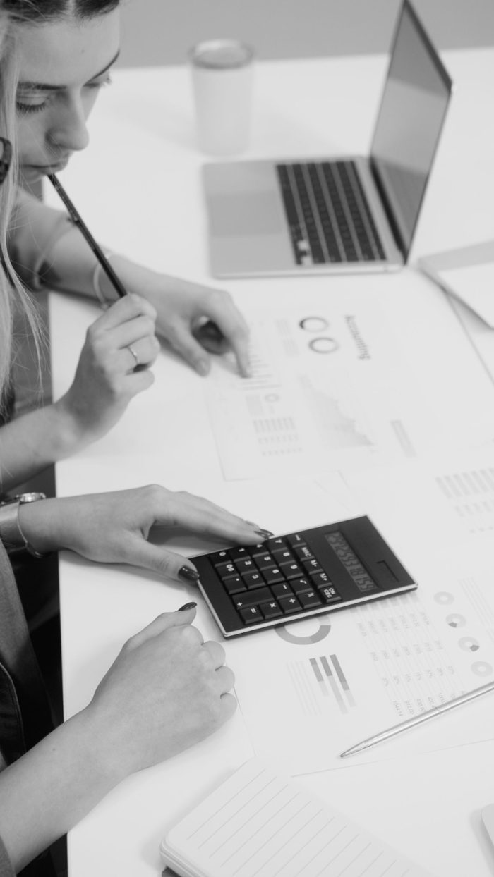 Profissional revisando cálculos e relatórios financeiros